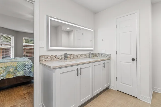 a bathroom with a granite countertop sink and a mirror