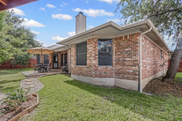 a view of a house with a yard and sitting area