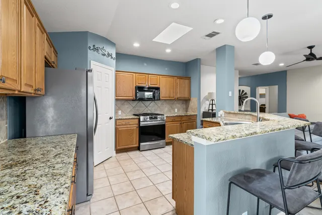 a kitchen with granite countertop a sink appliances and cabinets