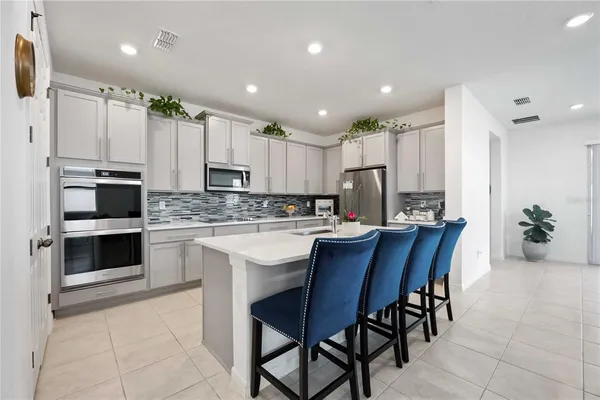a kitchen with kitchen island granite countertop a sink cabinets and stainless steel appliances