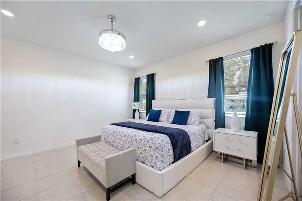 a spacious bedroom with a bed and a chandelier