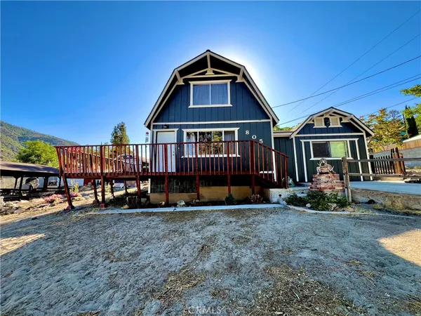 a view of a house with a yard and sitting area