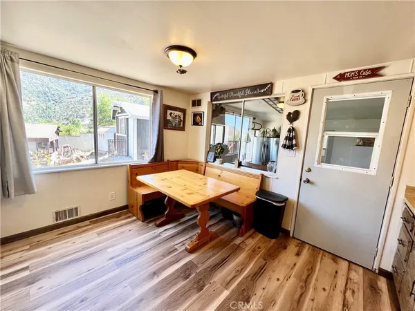 a room with wooden floor table and chairs