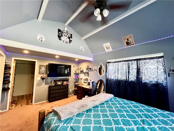 a large bedroom with a bed and a television