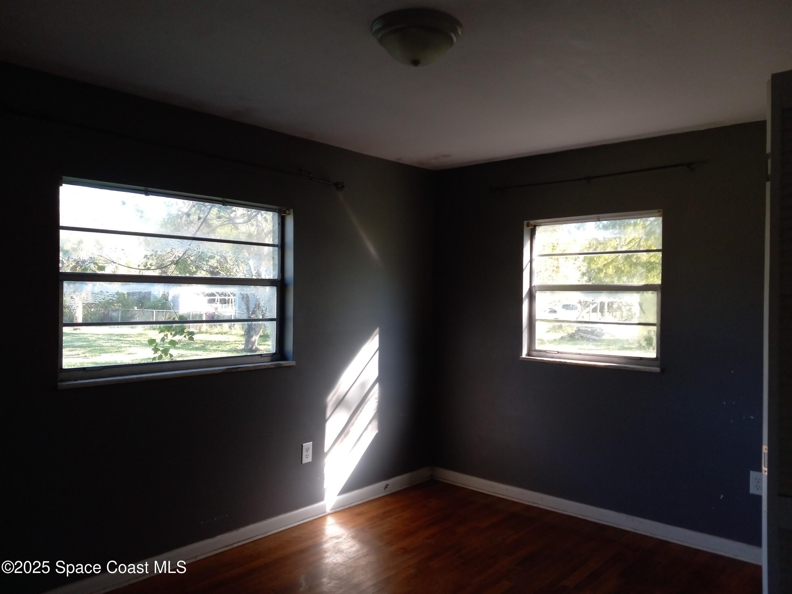 4335 Kumquat Street Cocoa, FL 32926 - Photo 12 of 21 a view of an empty room with wooden floor and a window