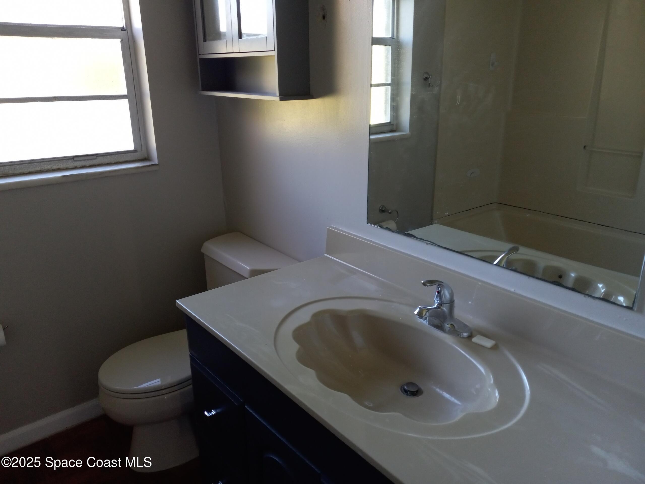 4335 Kumquat Street Cocoa, FL 32926 - Photo 18 of 21 a bathroom with a sink a toilet and a mirror
