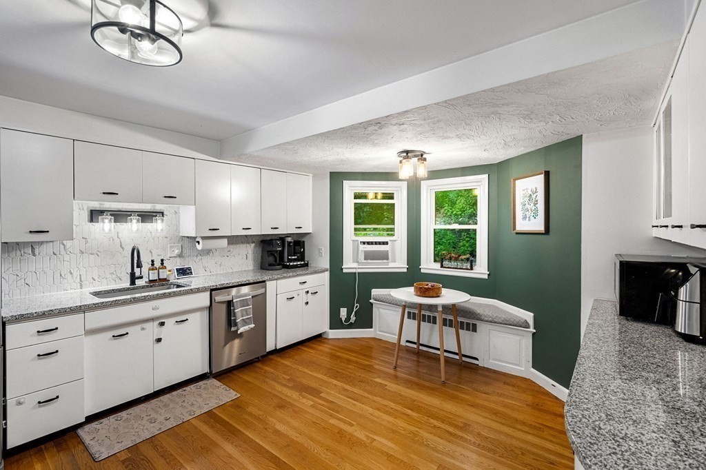 70 Indian Hill Road Worcester, MA 01606 - Photo 6 of 34 a kitchen with stainless steel appliances granite countertop a stove a sink dishwasher and white cabinets with wooden floor