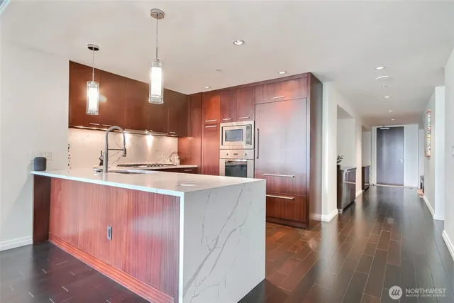 a kitchen with kitchen island a counter top space a sink appliances and cabinets