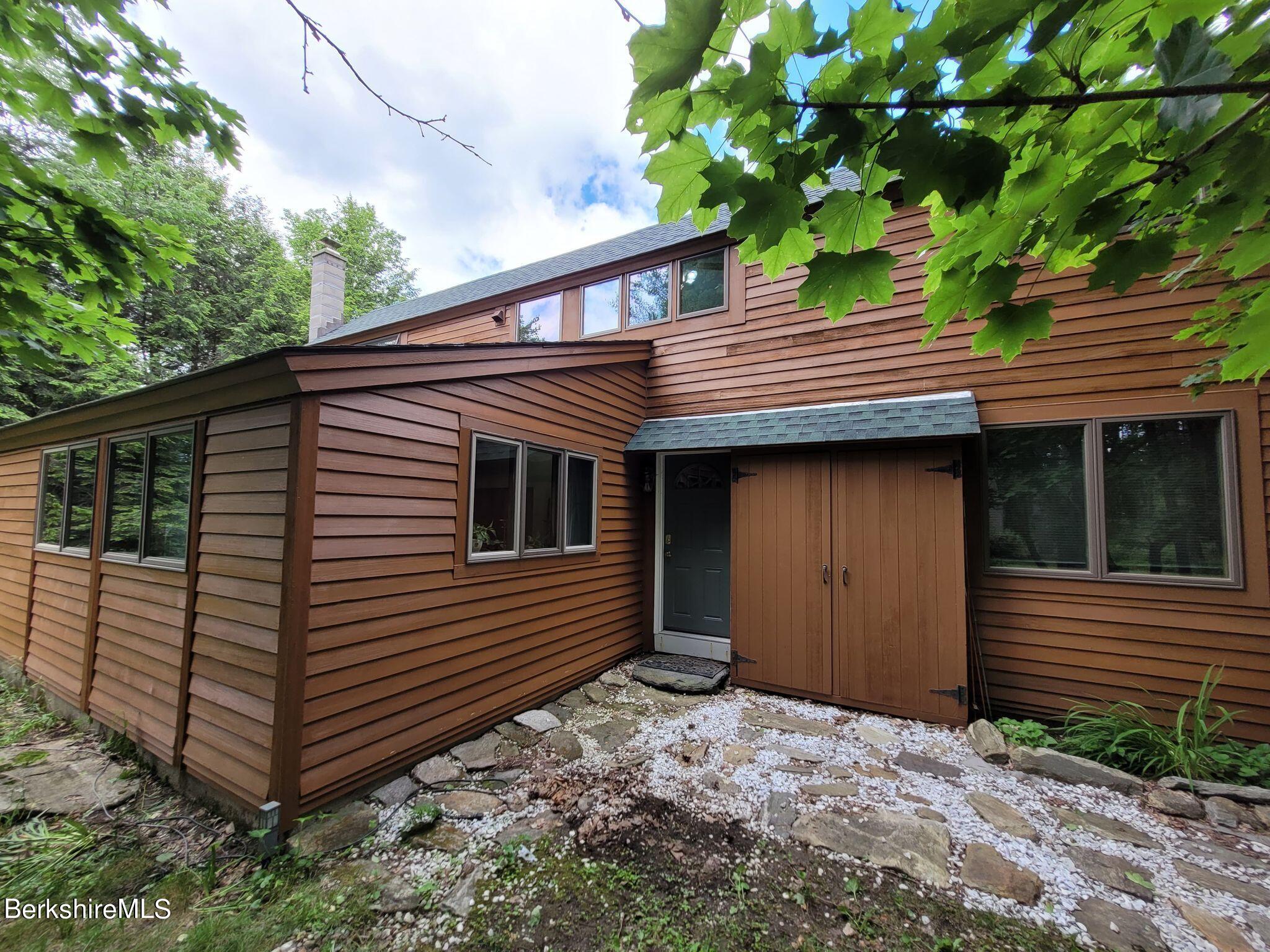 106 Access Road Becket, MA 01223 - Photo 1 of 43 a view of a house with a yard and garage