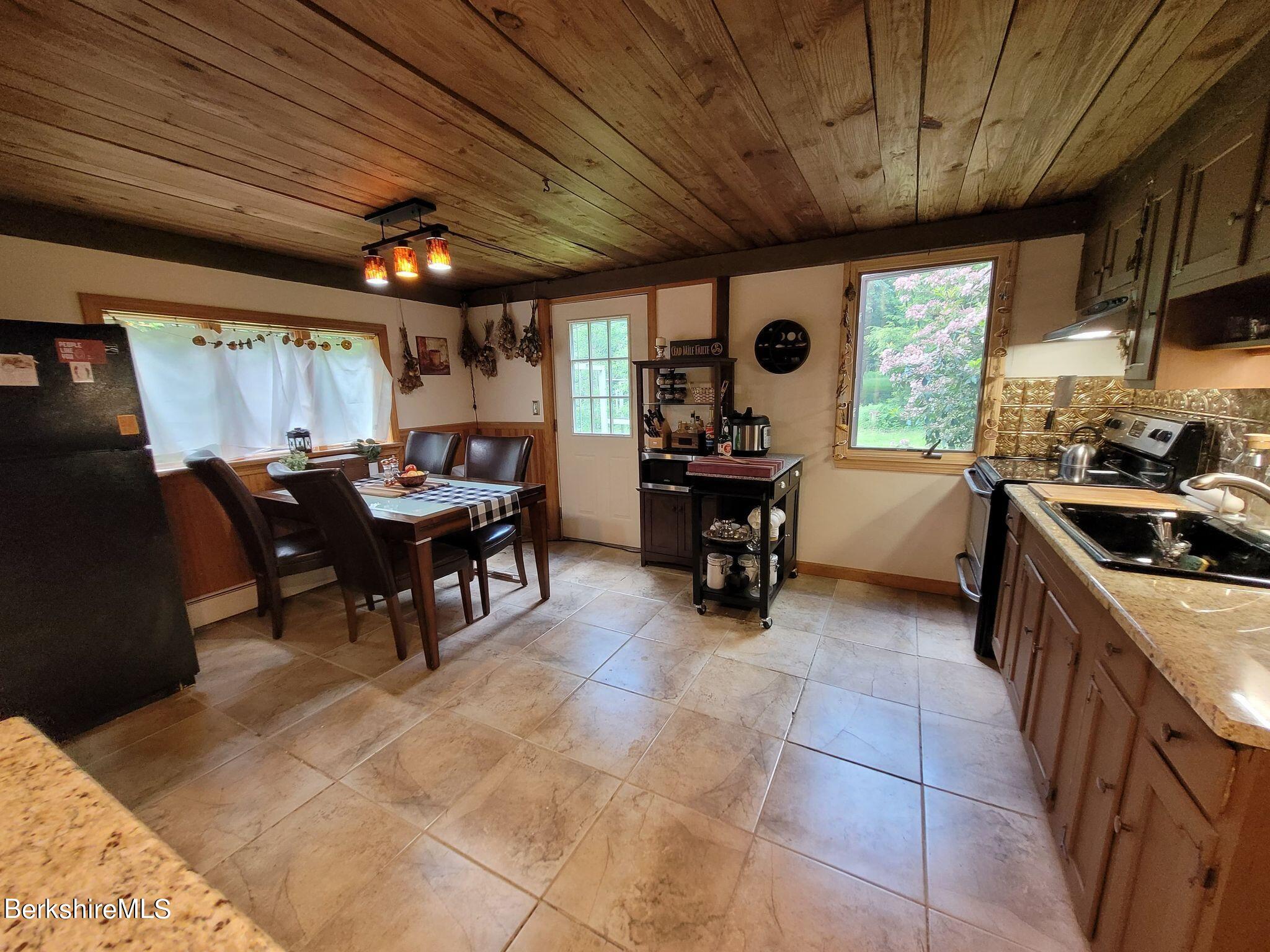 106 Access Road Becket, MA 01223 - Photo 12 of 43 a view of a kitchen with a sink and dishwasher a barbeque with wooden cabinets