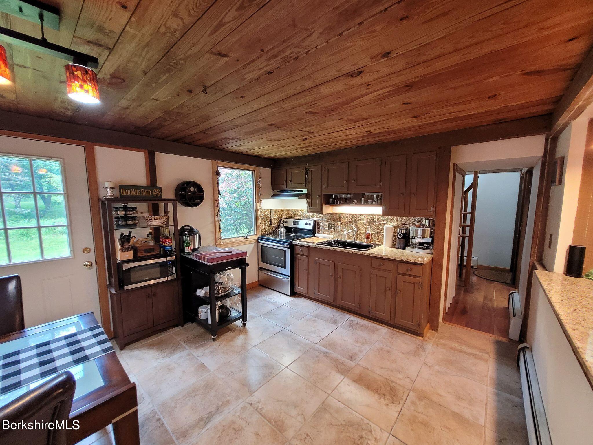 106 Access Road Becket, MA 01223 - Photo 16 of 43 a kitchen with a refrigerator and a wooden cabinets
