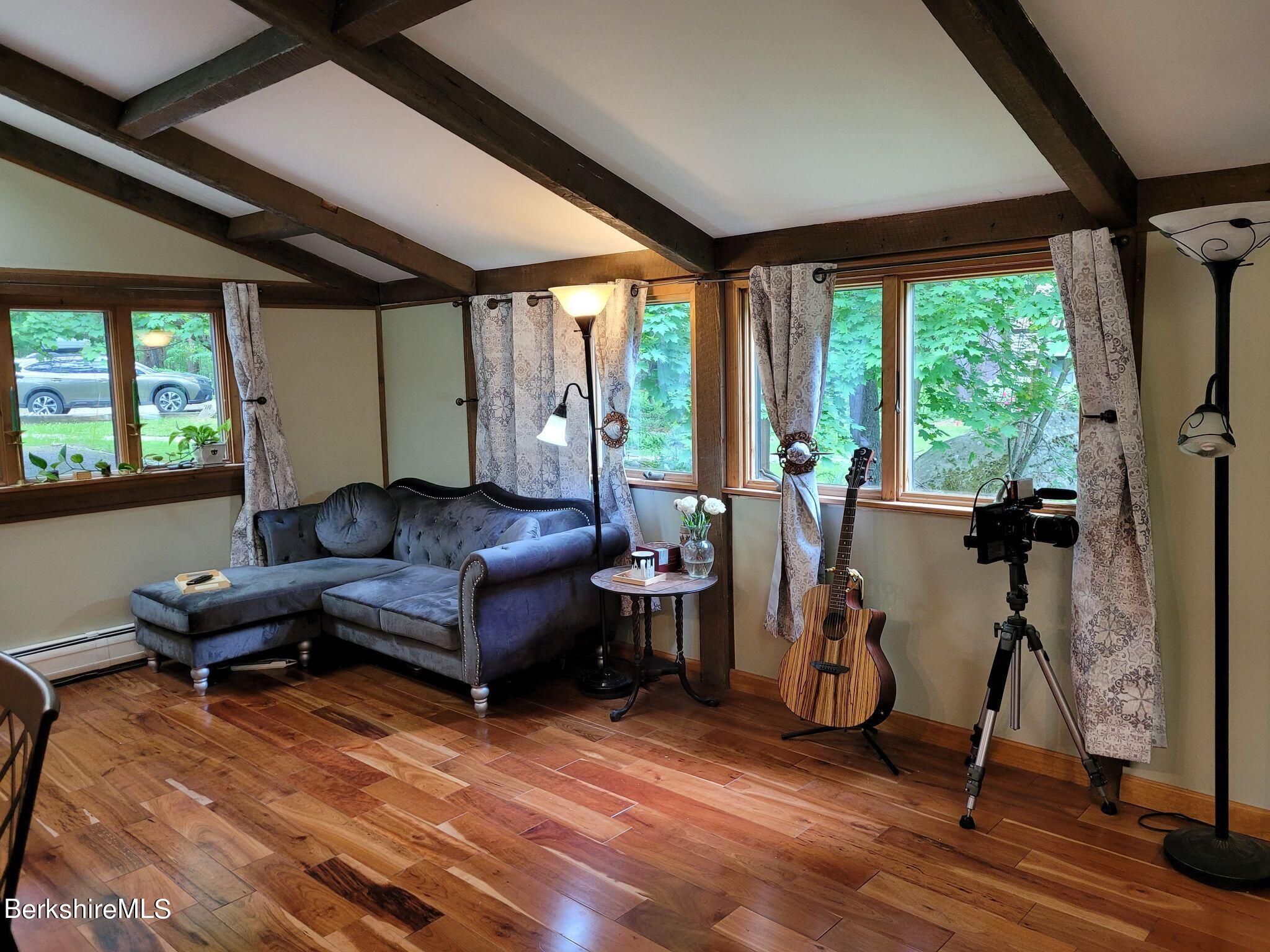 106 Access Road Becket, MA 01223 - Photo 17 of 43 a living room with furniture a large window and wooden floor