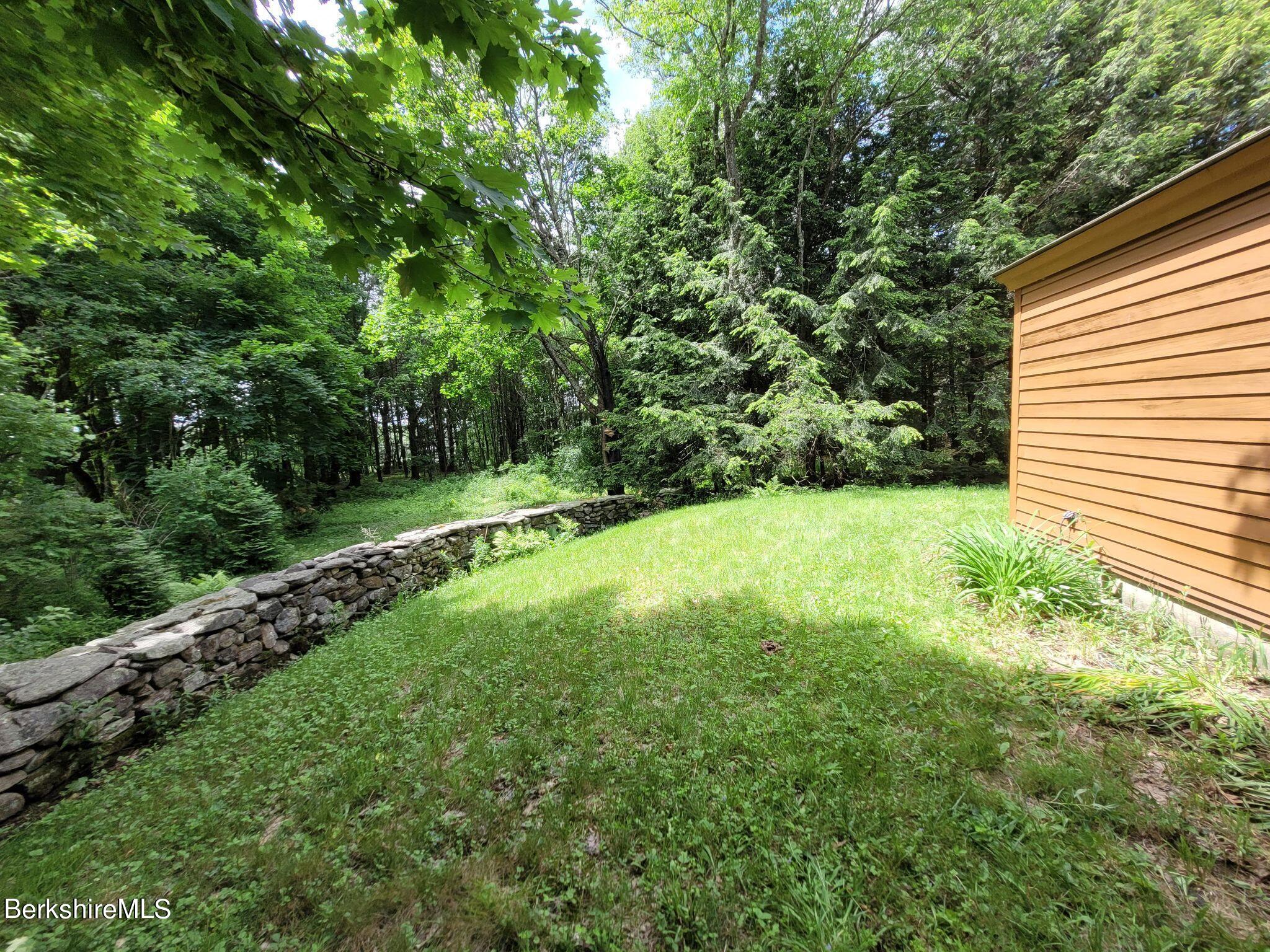 106 Access Road Becket, MA 01223 - Photo 7 of 43 a view of a green yard with a house