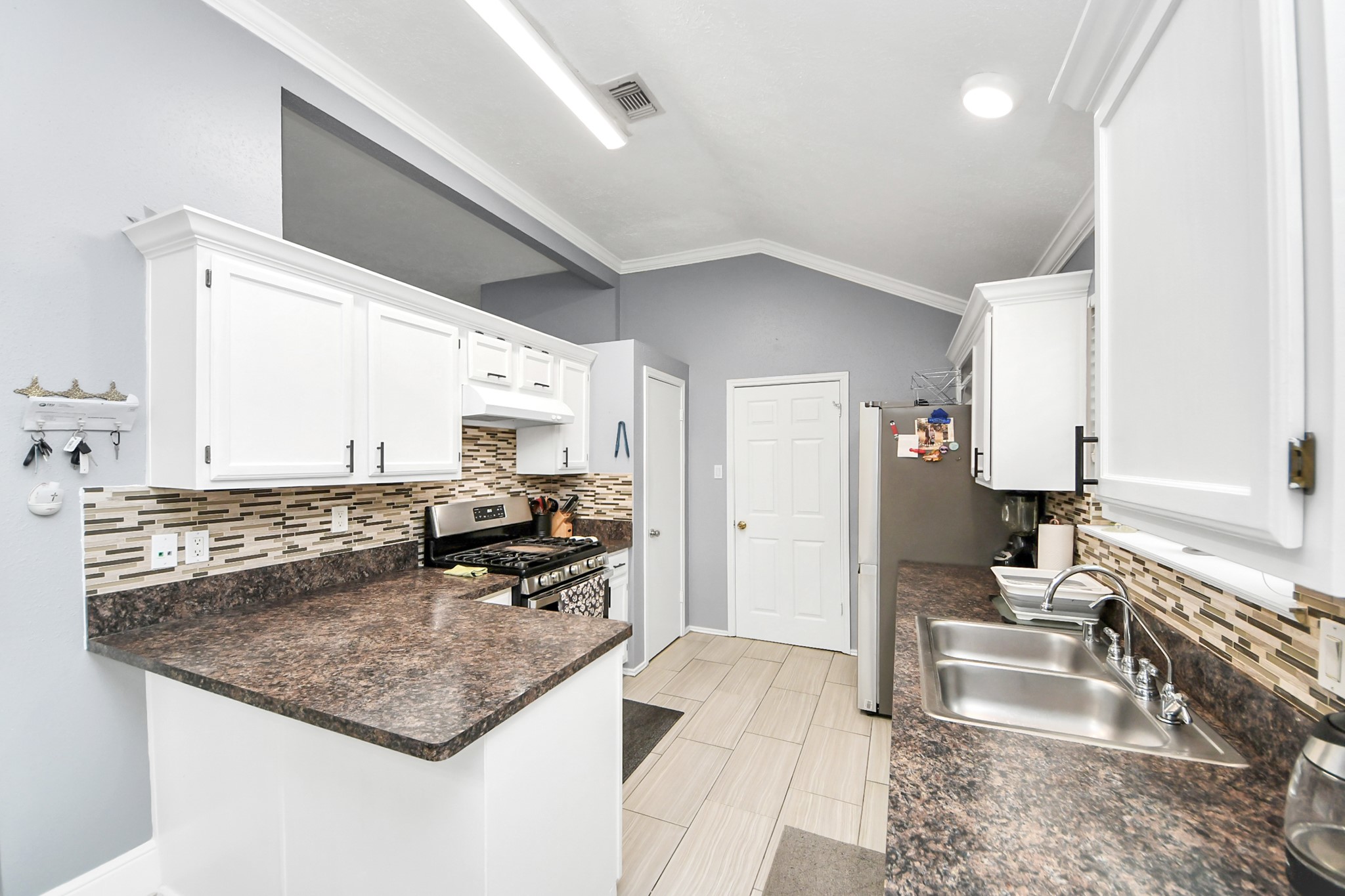 17702 Poppy Trails Lane Houston, TX 77084 - Photo 15 of 37 The heart of the home, this beautiful chef’s kitchen showcases modern white cabinetry, elegant granite countertops, and a stylish decorative backsplash.