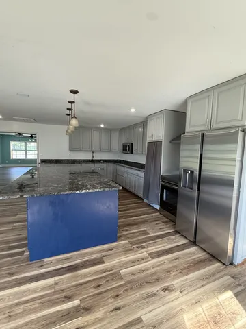 a kitchen with stainless steel appliances granite countertop a stove a sink and a refrigerator