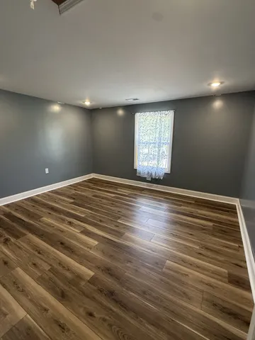 a utility room with wooden floor and cabinets