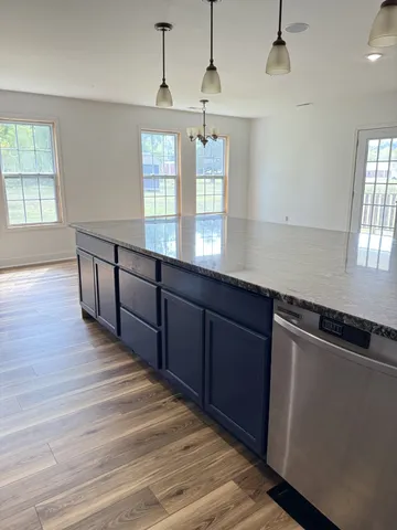 a kitchen with granite countertop white cabinets and sink