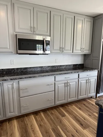 a kitchen with granite countertop white cabinets and sink