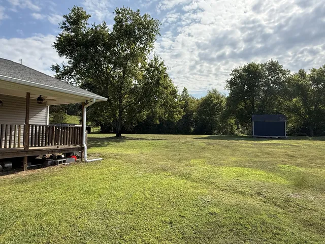 a view of a house with backyard and sitting area