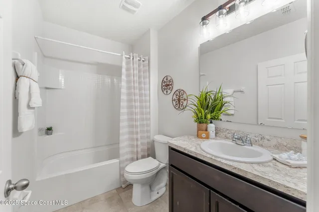 a bathroom with a granite countertop sink a toilet and shower