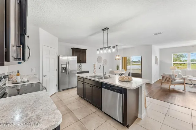 a kitchen with stainless steel appliances granite countertop a sink and a refrigerator