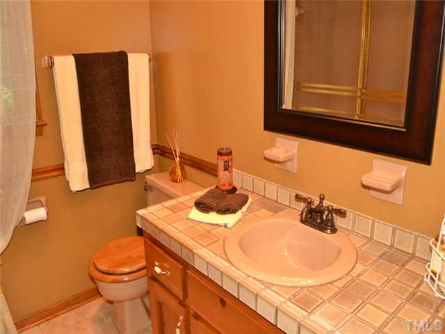 5304 Deep Valley Run Raleigh, NC 27606 - Photo 15 of 25 Hall bath updated with tiled counter/backsplash and ceramic tile flooring. Bathroom