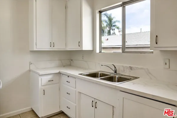 a kitchen with white cabinets and a sink