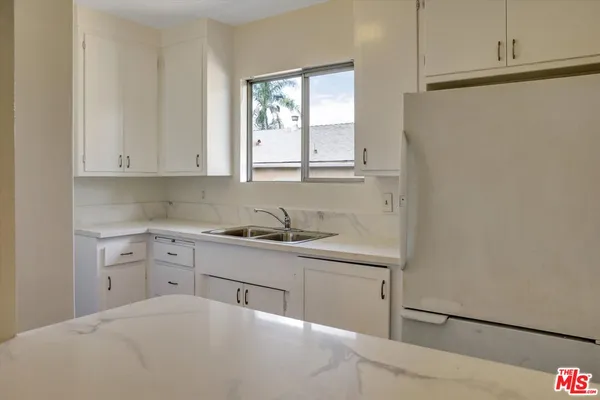 a room with a window cabinets and washer