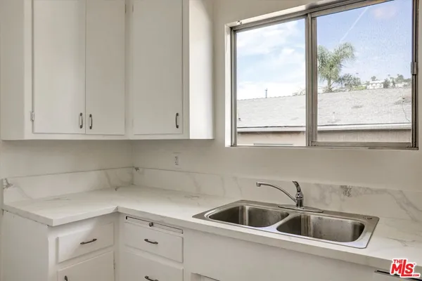 a kitchen with white cabinets and a sink