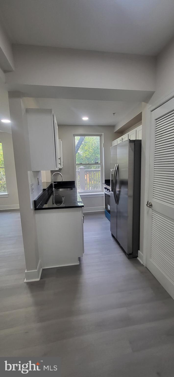 1108 Columbia Road Northwest, Unit 202 Washington, DC 20009 - Photo 5 of 19 a view of kitchen with stainless steel appliances kitchen island hardwood floor and a window