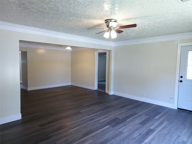 an empty room with a ceiling fan and a window