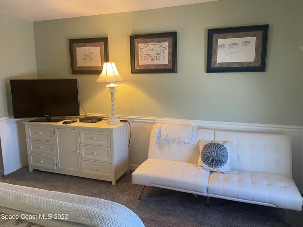 a bed sitting in a bedroom next to a lamp