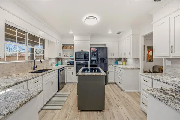 a kitchen with a stove sink and cabinets