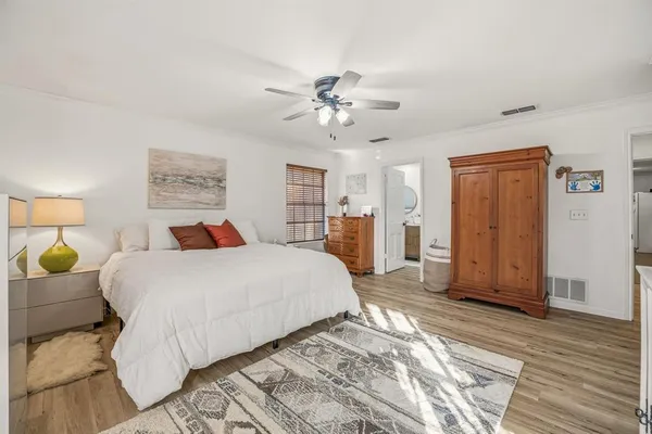 a bedroom with a large bed chandelier and a window