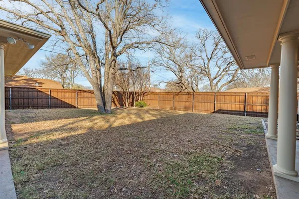 a view of backyard with wooden fence