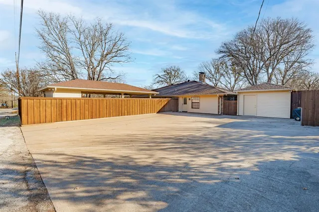 a front view of a house with a yard and wooden fence