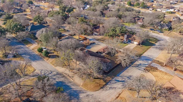 an aerial view of house with yard and mountain view in back