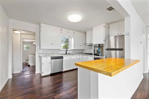 a kitchen with stainless steel appliances granite countertop refrigerator sink and cabinets
