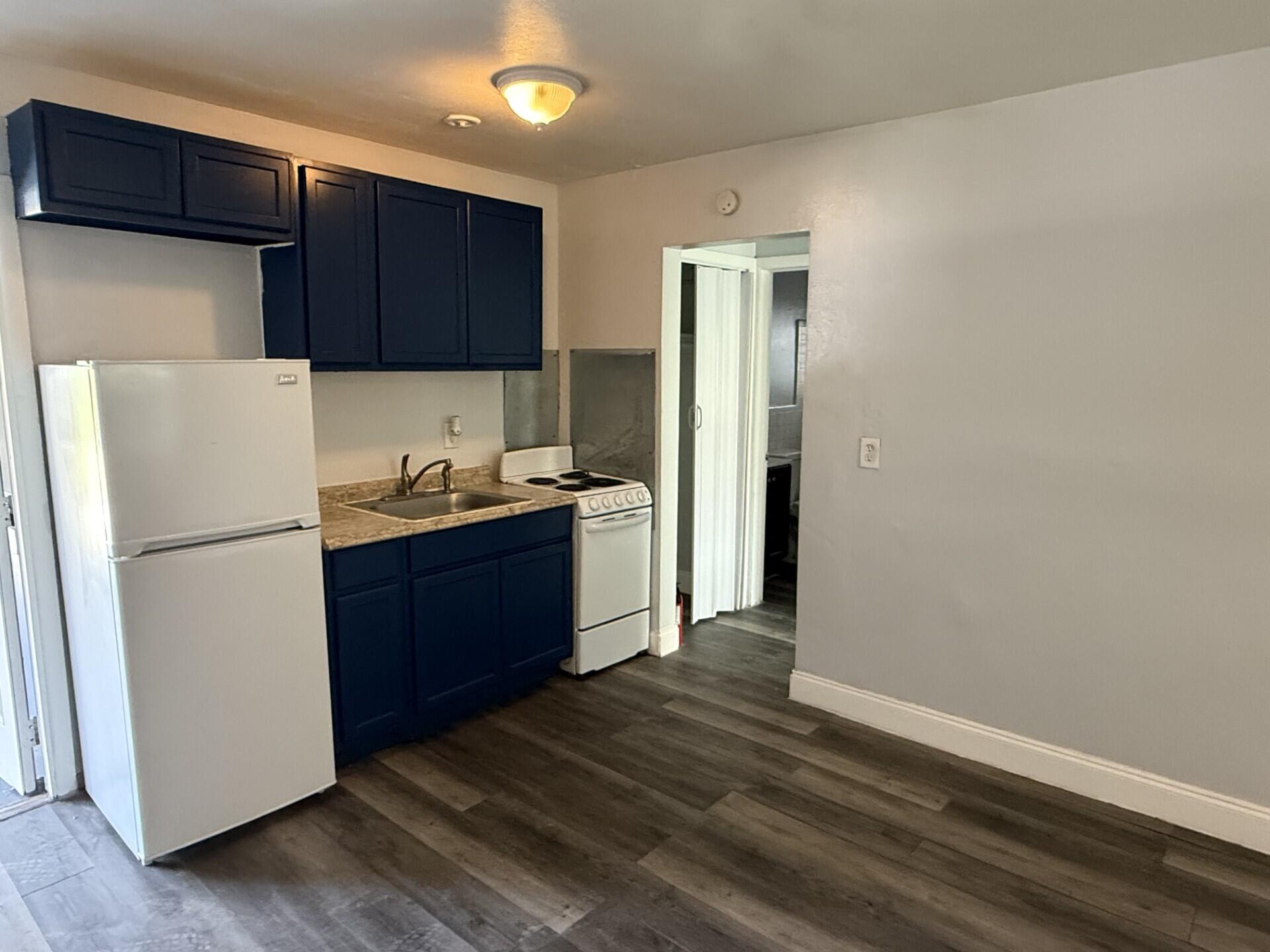131 East 27th Street, Unit 4 Riviera Beach, FL 33404 - Photo 3 of 10 a kitchen with a refrigerator and a stove