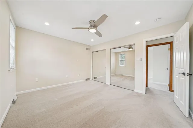 an empty room with closet and a ceiling fan