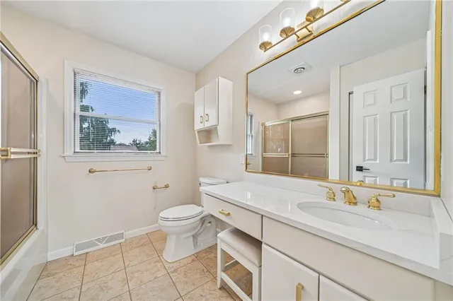 a bathroom with a granite countertop sink mirror and toilet