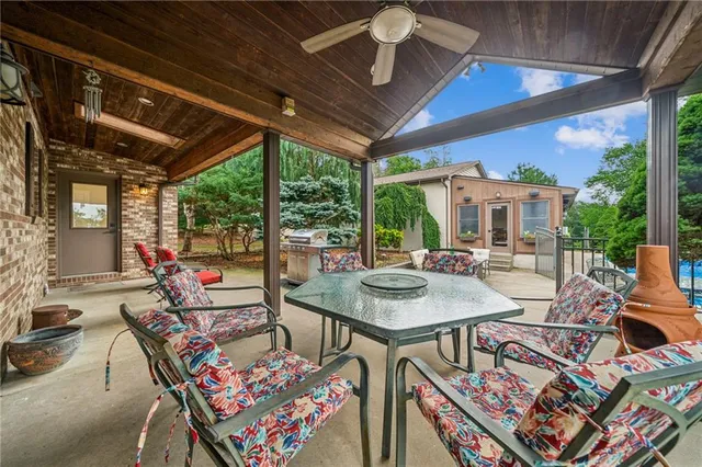 a patio with a table and chairs and potted plants