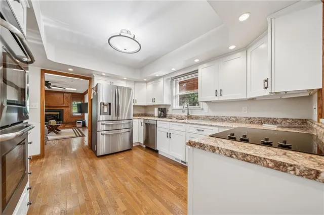 a kitchen with a sink a counter top space stainless steel appliances and cabinets
