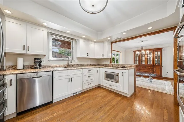 a kitchen with stainless steel appliances granite countertop a stove cabinets and wooden floor