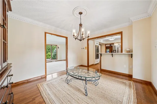 a living room with wooden floor and a chandelier