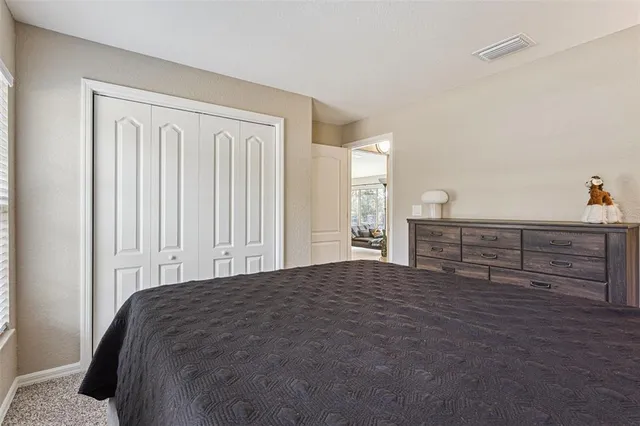 a spacious bedroom with a bed and a cabinets