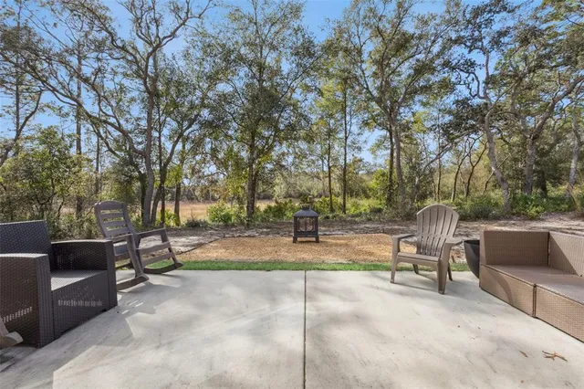 a view of backyard with outdoor seating and trees