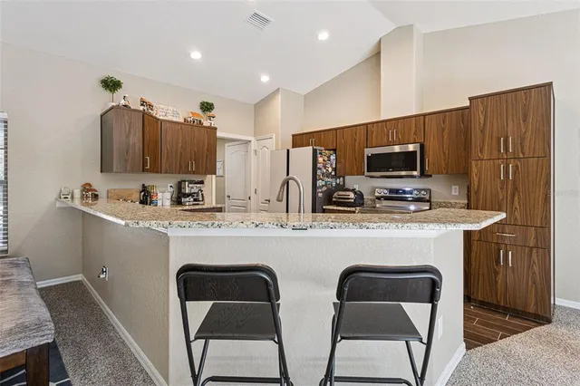 a kitchen with stainless steel appliances a stove refrigerator sink and microwave