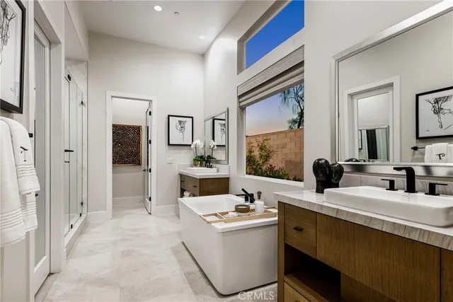 a bathroom with a double vanity sink mirror and bathtub