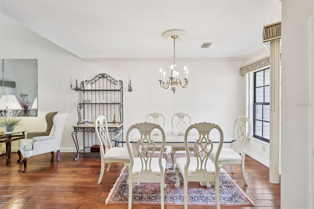 116 Baytree Boulevard Tavares, FL 32778 - Photo 11 of 47 a view of a dining room with furniture a chandelier and wooden floor